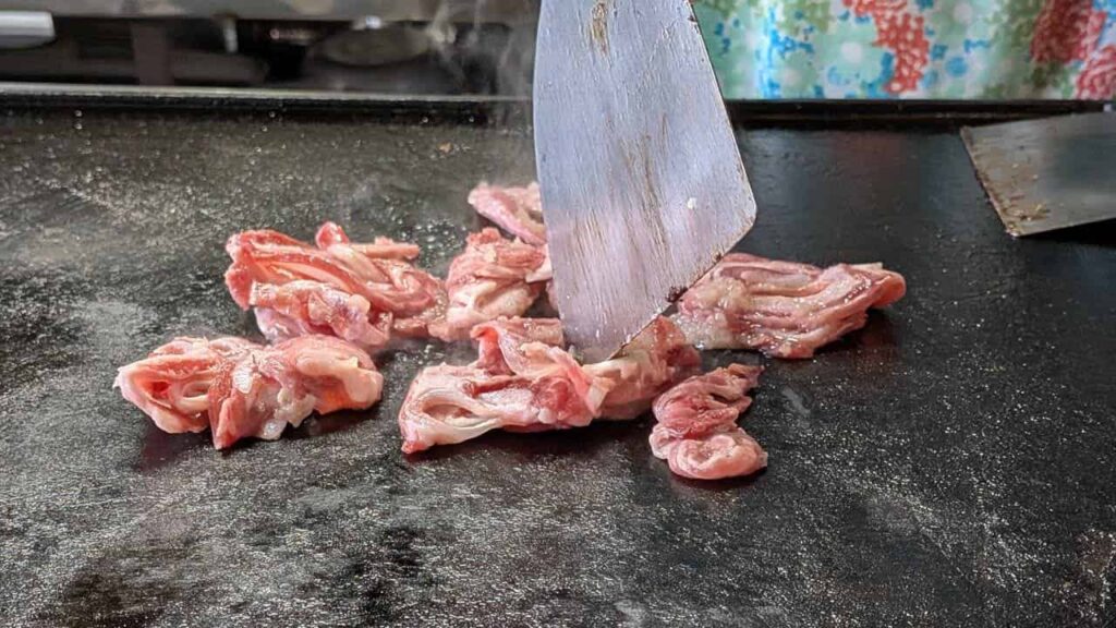 『遊味亭』鉄板でお肉を焼いている